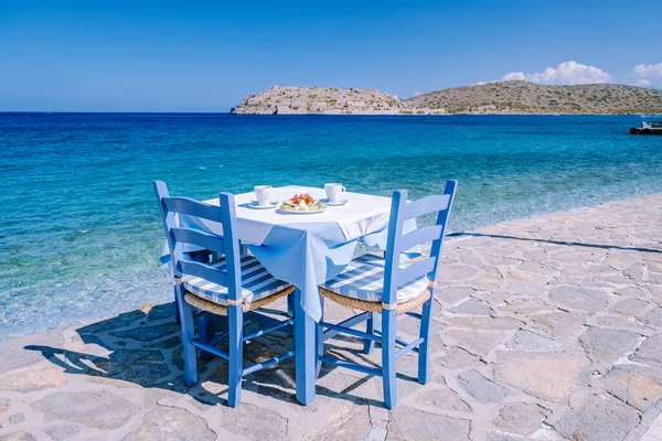 Plaka Lassithi s je tradiční modrý stůl a židle a pláž na Krétě Řecko — Stock fotografie
