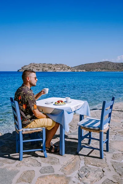 Plaka Lassithi met is traditionele blauwe tafel en stoelen en het strand in Kreta Griekenland — Stockfoto