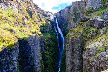 Glymur uzun ve güçlü, sarp kayalıklardan güzel bir şekilde düşen şelale, yemyeşil yosun ve kayalık arazi ile çevrili, İzlanda 'nın nefes kesici doğal güzelliğini gözler önüne seriyor..
