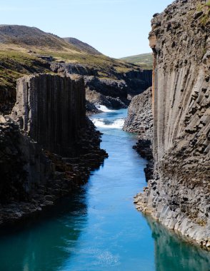 Ziyaretçiler, Studlagil Kanyonu 'ndaki çarpıcı bazalt sütunlara ve turkuaz nehrine hayret ediyorlar. İzlandalılar, doğa harikalarını hayrete düşürüyorlar. Açık hava maceraları ve fotoğrafçılık için mükemmeller..