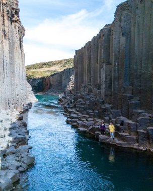 Gezginler, İzlanda 'daki Studlagil Kanyonu' ndaki çarpıcı bazalt sütun oluşumları ve canlı turkuaz suları karşısında büyülendiler. Dramatik manzara unutulmaz bir açık hava macerası yaratır..