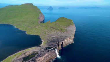 Şelalelerin denize döküldüğü Faroe Adaları 'nın nefes kesici uçurumlarını keşfedin. Bereketli yeşil arazi derin mavi okyanusla buluşur, Sorvagsvatn Gölü, Vagar