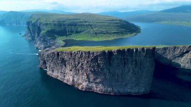 Faroe Adaları 'nın büyüleyici kayalıklarını ve bereketli manzaralarını keşfedin. Hava perspektifi deniz ve kara arasındaki büyüleyici zıtlıkları gözler önüne seriyor. Dokunulmamış güzellikleri ve cazibeleri gözler önüne seriyor..