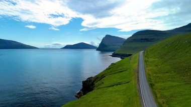 Sakin bir günde Faroe Adaları 'ndaki engebeli kıyı şeridi ve sakin suların nefes kesici manzarası. Vidareidi 'yi keşfeden doğa aşıkları ve maceraperestler için mükemmel.