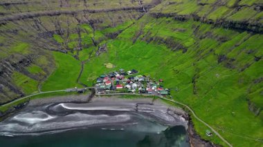 Tjornuvik 'in nefes kesici manzarasını keşfedin. Faroe Adaları' ndaki yüksek uçurumlar ve canlı yeşil tepeler arasında yuva yapmış tuhaf bir köy. Huzurlu ortamın tadını çıkar..
