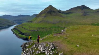 Faroe Adaları 'ndaki Tjornuvik' in göz kamaştırıcı manzaralarında engebeli dağlar ve sakin sular yer almaktadır..