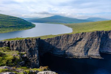 Sakin sularla buluşan nefes kesen uçurumlar bu manzara Faroe Adaları 'nın özünü yakalar. Sorvagsvatn Gölü