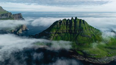 Faroe Adaları 'nın çarpıcı doğal güzelliklerini keşfedin, dramatik uçurumlar, yemyeşil tepeler ve yumuşak, dalgalı sis. Drangarnir uçurumları