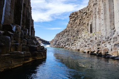İzlanda, Studlagil Kanyonu 'ndaki berrak sulardan yükselen çarpıcı bazalt sütunlara hayret. Bu gizli mücevher, dünya dışı bir manzaranın ihtişamını sergiliyor..
