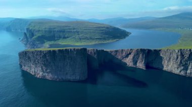 Sakin sulardan yükselen görkemli uçurumların olduğu Faroe Adaları 'nın dramatik sahil şeridini keşfedin. Bereketli yeşil arazi huzurlu denizle buluşur, Sorvagsvatn Gölü, Vagar