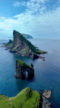 Dramatik Drangarnir uçurumlarını ve sakin okyanus sularıyla çevrili Faroe Adaları 'nın engebeli arazisini gösteren geniş bir manzara. Doğa meraklıları ve manzara severler için ideal. 