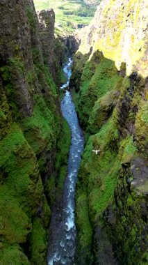 İzlanda 'daki Mulagljufur Kanyonu' nda görkemli kayalıklar ve yemyeşil yemyeşil, dramatik manzarası boyunca akan yumuşak bir nehir, İzlanda 'nın huzurlu güzelliğini vurguluyor.