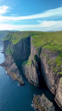 Bereketli yeşillik Faroe Adaları 'nın engebeli manzarasını kaplarken heybetli uçurumlar sakin suların üzerinde kule gibi.. 