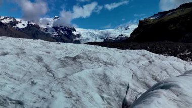 İzlanda 'daki Svinafellsjokull Buzulu' nu araştırın. Karmaşık buz kalıpları ve engebeli araziler karamsar bir gökyüzü altında çarpıcı bir manzara yaratır..