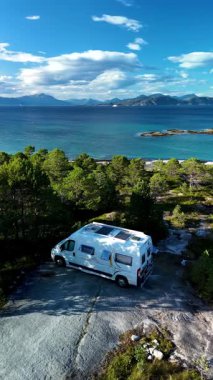 Norveç 'in Bognes kentindeki bu pitoresk yer, masmavi suların ve etrafındaki dağların nefes kesici manzaralarını sunuyor. Nordland sahiline park etmiş bir karavan.