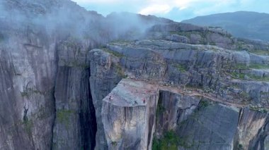 Norveç 'teki Preikestolen' in çarpıcı güzelliğini tecrübe edin. Cesur maceracılar, dramatik manzaralara ve yuvarlanan sise tepeden bakan ikonik uçurumun üzerinde dururlar. Bu huzurlu ortamda macera bekliyor..