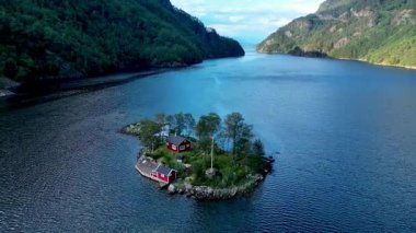 Derin mavi sular ve yemyeşil tepelerle çevrili küçük bir adaya kurulmuş güzel kırmızı bir kulübe. Fiyordun sakinliği Norveç 'in doğal güzelliğini yansıtıyor..