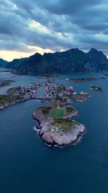Lofoten, Norveç 'teki Henningsvaer' in büyüleyici manzaralarını keşfedin. Resimli adaların kasvetli bir gökyüzünün altında dramatik tepelerle buluştuğu yerleri. Bu eşsiz yerde sanat deneyimi..