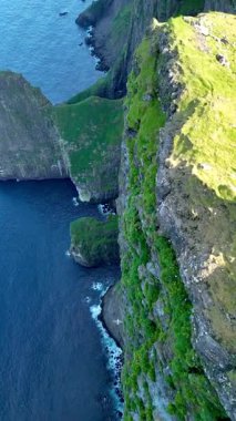Faroe Adaları 'ndaki yüksek uçurumların ve canlı suların nefes kesen manzarası. Saf güzellikleri sergiliyor. Huzurlu bölgelerde ilham arayan maceracı ruhlar için mükemmel..