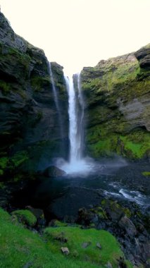 İzlanda 'daki nefes kesen Kvernufoss şelalesinin yosun kaplı kayalıkların üzerinde zarifçe yuvarlanarak sakin ve sakin bir atmosfer yarattığını hissedin..