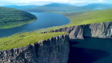 Çarpıcı hava manzaraları Faroe Adaları 'nın görkemli uçurumlarını ve sakin sularını gösteriyor. Bereketli yeşil manzaralar, parlak gökyüzünün altında derin mavi denizlerle buluşup, pitoresk bir doğa harikası yaratır..