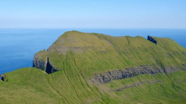 Soluk kesici Mylingur uçurumları yemyeşil çimlerle örtülmüş Faroe Adaları 'ndaki derin mavi okyanustan dramatik bir şekilde yükseliyor..
