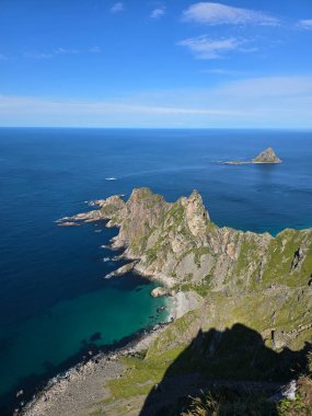 Engebeli uçurumların berrak mavi bir gökyüzünün altında durgun denizle buluştuğu Andoya, Bleik 'teki Matind Dağı' ndan bakarken büyüleyici manzarayı deneyimleyin..