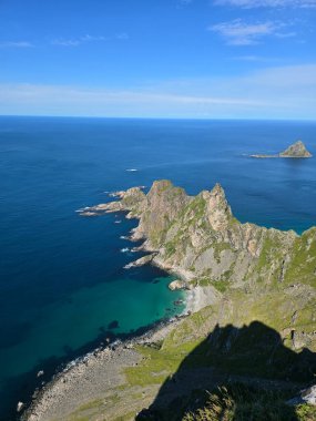 Matind Dağı 'nın zirvesinden Andoya' nın çarpıcı sahil şeridine bakın. Dramatik uçurumlar ve berrak turkuaz sular büyüleyici bir manzara yaratır..