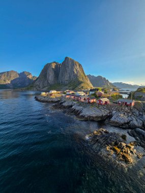 Hamnoy 'un büyüleyici kırmızı kulübelerini gösteren nefes kesici kıyı manzarası görkemli dağlara ve kristal berrak sulara yuva yapmış. Norveç 'in doğal güzelliklerini sergilemek için mükemmel..