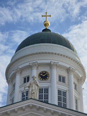 Helsinki, Finlandiya, 25 Ağustos 2025 Helsinki Katedrali 'nin ikonik kubbesi görkemli bir şekilde kabarık bulutlara karşı yükselir. Kubbenin tepesindeki altın haç güneş ışığında parlıyor.