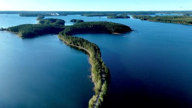 Doğa Köprüsü Esker, yoğun ormanlarla çevrili sakin göllerle Fin manzaralarını nefes kesici bir şekilde sunar. Göl manzaralı bir yol, doğal orman, Punkaharju Doğa Koruma Alanı 