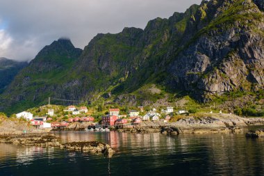 Soluk kesici Lofoten Adaları 'na yerleşmiş renkli kulübeler sakin suları yansıtıyor. Göz kamaştırıcı tepelerle çevrili bu sakin manzara şafak vakti Norveç 'in doğal güzelliğini yakalar..