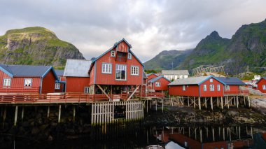Dramatik dağların arasına yerleşmiş, sakin suların yanındaki sütunlarda gururla duran kırmızı kulübeler. Norveç 'in A Lofoten şehrindeki bu cennet gibi yer doğa ve geleneğin mükemmel bir karışımını sunuyor..