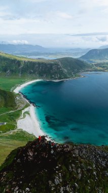 Mannen 'in zirvesinden nefes kesen manzara, kristal berrak suları ve Haukland, Lofoten' in beyaz kumlu plajlarını gözler önüne seriyor..