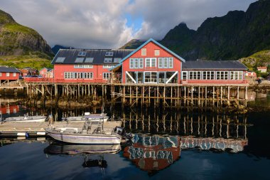  Bir Lofoten, Norveç, 13 Ağustos 2025, Vibrant kırmızı binalar durgun su üzerinde yükseldi, benzersiz bir mimari sergilenen 