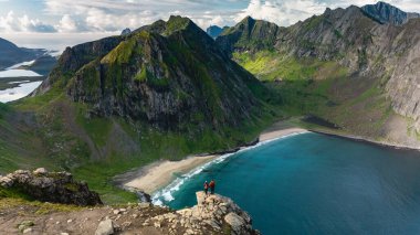 Yürüyüşçüler Ryten Kvalvika Sahili 'ndeki dramatik kayalıklara ve turkuaz sulara hayran kalırken, Lofoten' in engebeli güzelliğini keşfedin. Bu çarpıcı mekan macera ve sükunetin mükemmel bir karışımını sunuyor..