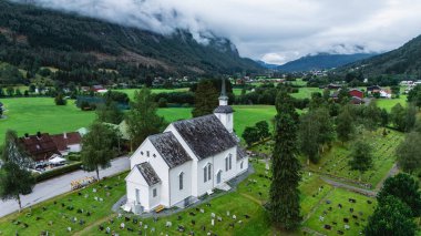 Resmedilmeye değer Stryn vadisine bakan büyüleyici beyaz kilise yeşil tarlaların ve dağların arasında duruyor..