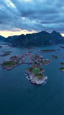 Sakin sular ve görkemli dağların arasına yerleşen Henningsvaer, alacakaranlıkta canlı mimari ve çarpıcı manzaralar sergiliyor. Bu kıyı köyünün büyüleyici atmosferini tecrübe edin..