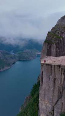 Norveç 'te, maceraperest yürüyüşçülerin Lysefjord' un üzerindeki panoramik manzaralardan hoşlandıkları göz kamaştırıcı manzaraları deneyimleyin. Sis sarar kayalık kayalıkları, gizemli bir atmosfer yaratır..