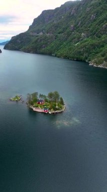 Norveç 'in sakin sularında yuva yapmış küçük bir adada yemyeşil yemyeşil büyüleyici kırmızı kulübeler bulunur. Arka planda görkemli dağlar yükselir ve çarpıcı bir doğal zemin oluşturur..