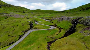 Faroe Adaları 'nın yemyeşil tepeleri arasında yuva yapmış nefes kesen yolu keşfedin..