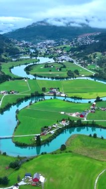 Norveç, Stryn 'in büyüleyici güzelliğini, yemyeşil tarlaları ve kıvrımlı nehirleriyle tecrübe edin. Bu büyüleyici manzara doğa cazibesini ön plana çıkarıyor, gezginleri ve doğa aşıklarını davet ediyor..