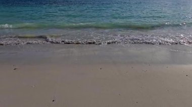 Lofoten Norveç 'teki güzel bir kumsalın kumlu sahil şeridini öperken sakin sularda yumuşak sabah ışığı dans ediyor. Huzurlu manzara huzur ve gevşemeyi davet ediyor..