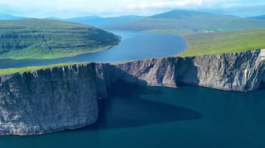 İkonik Faroe Adaları 'ndaki sakin suların üzerinde yükselen nefes kesici uçurumlar. Sorvagsvatn Gölü, Vagar