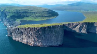 Faroe Adaları 'nın görkemli güzelliğini, yükselen kayalıkların dingin sulara kavuşmasını tecrübe edin. Bereketli yeşil manzaralar, Sorvagsvatn Gölü 'nün engebeli kıyı şeridi Vagar' a karşı çarpıcı bir tezat oluşturuyor.