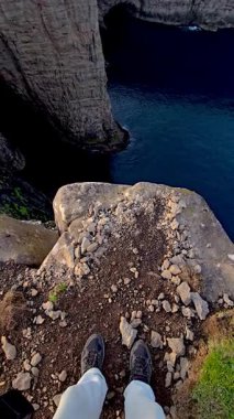 Engebeli bir uçurumun tepesinde, Faroe Adaları 'nın nefes kesen genişliği aşağıya doğru uzanır. Kayalık çıkıntı canlı mavi denizle buluşur, bu uzak cennetin büyüleyici doğal güzelliğini gözler önüne serer..