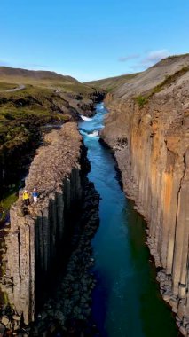 İzlanda 'daki Studlagil Kanyonu' nun nefes kesen güzelliğini deneyimleyin. Orada yükselen bazalt sütunlar huzurlu bir nehirle kesişir. Bu inanılmaz İzlanda harikasının canlı renklerini ve eşsiz jeolojisini keşfedin..