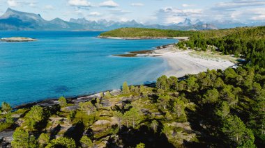 Bognes, Lofoten 'daki çarpıcı kıyı manzarası kristal berrak suları, yemyeşil suları ve uzaktaki görkemli dağları gösteriyor. Norveç 'in doğal cazibesinin mükemmel bir temsili..