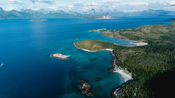 Turkuaz sular Bognes Lofoten, Norveç 'te yeşil manzaralarla karşılaşıyor. Bu nefes kesici hava manzarası sakin plajları ve kayalık kıyı şeritlerini parlak bir gökyüzü altında yakalıyor, keşif ve macerayı davet ediyor..