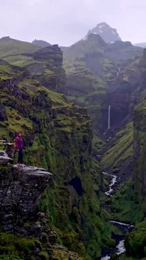 İzlanda 'daki Mulagljufur Kanyonu' nun kenarında duran maceraperest, yemyeşil ve çağlayan şelalelerle çevrili. Büyüleyici bir doğa karışımı güzellik ve engebeli arazi ortaya çıkıyor..